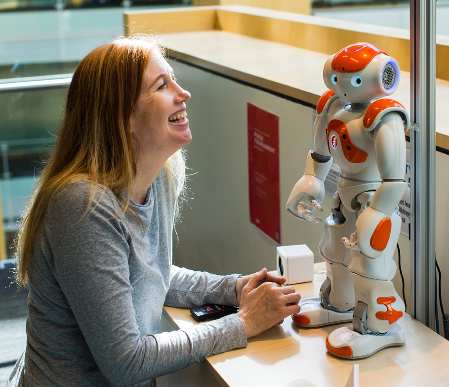 Jaime Teevan working with a small human-like robot